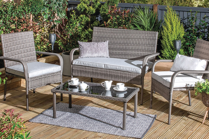 Grey rattan garden furniture with sofa and armchairs on light wood decking