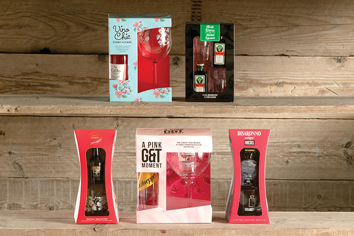 Five gift sets containing different types of alcohol against a wooden background