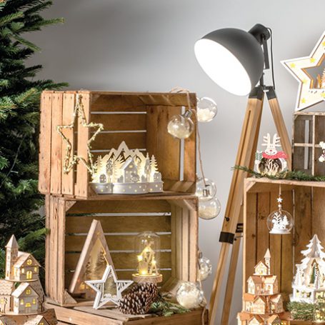 Scandi themed christmas decorations on wooden crates lit by a lamp