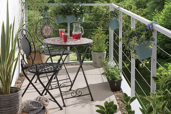 Metal and mosaic bistro set on a balcony with plants
