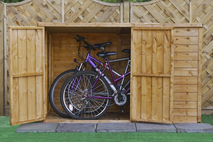 Bike shed with one door open revealing two purple bikes inside