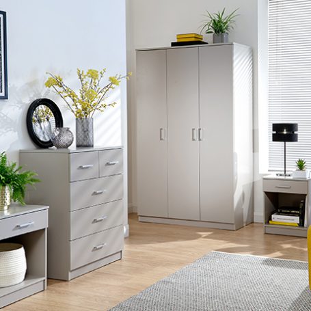 Matching set of light grey bedroom furniture alongside a mustard yellow bedstead in a decorated bedroom