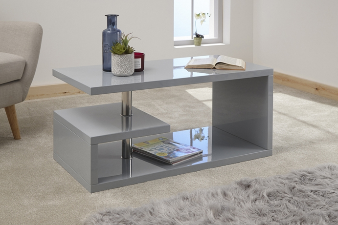 A high gloss grey modern coffee table dressed with a houseplant and reading books