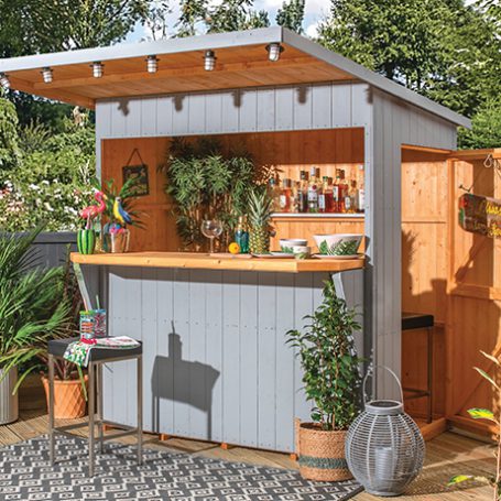 An outdoor bar shed in the sunshine decorated with tropical ornaments and lighting