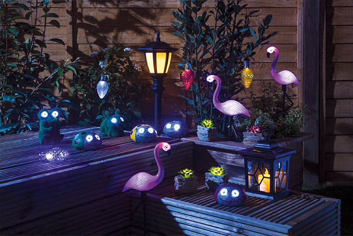 A collection of tropical themed solar lighting neatly arranged in a garden at night time