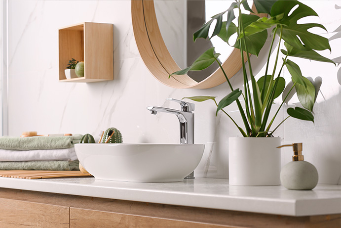 bathroom sink cabinet with natural wood cupboards adorned with house plants