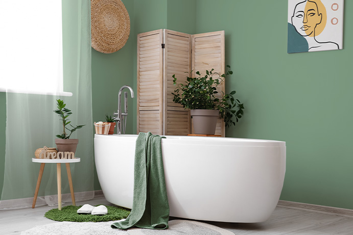 green bathroom with a vibrant painting and lots of decorative accessories